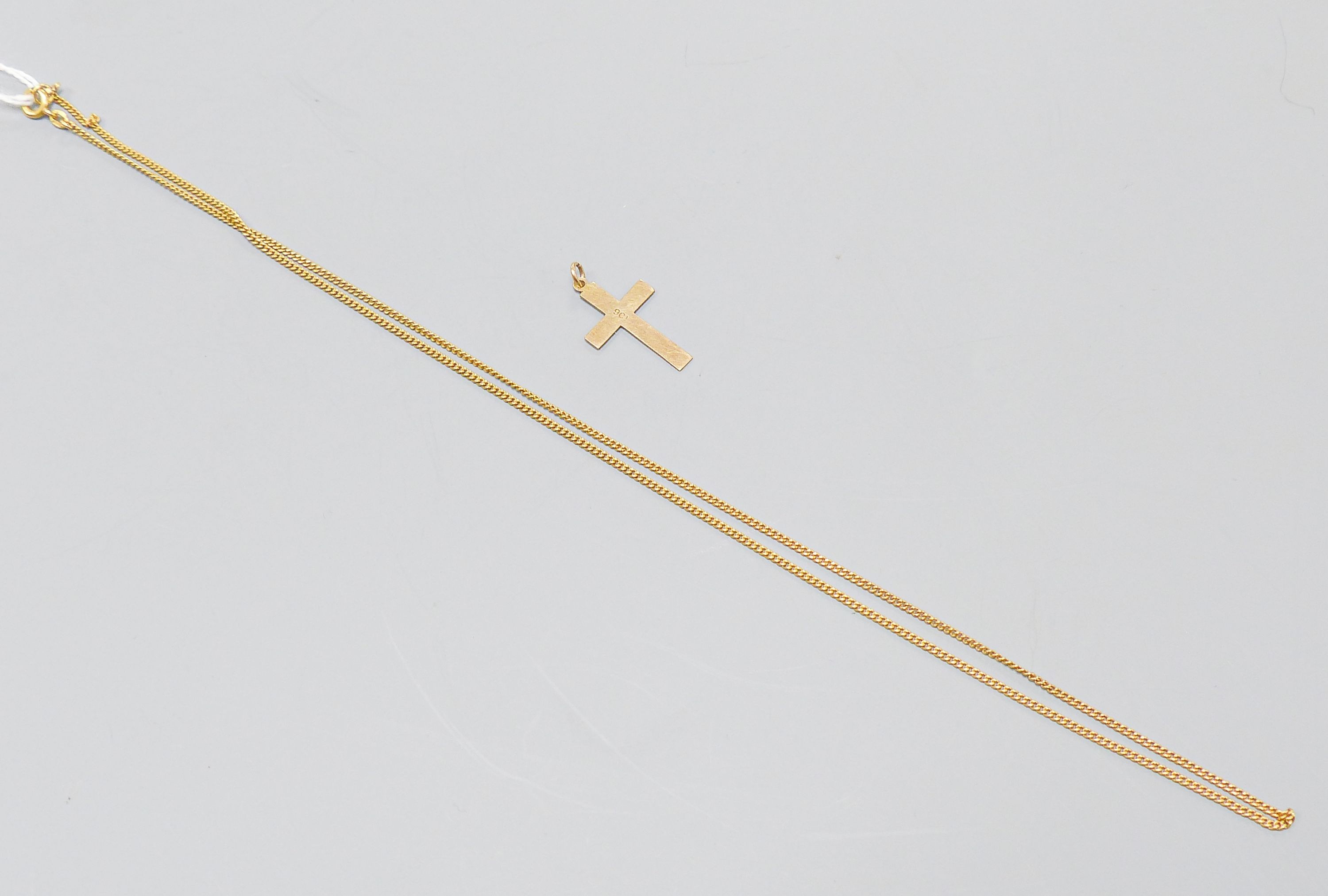 An 18ct yellow gold fine curb-link necklet, 51cm, 5 grams and a 9ct crucifix, 0.8 grams.